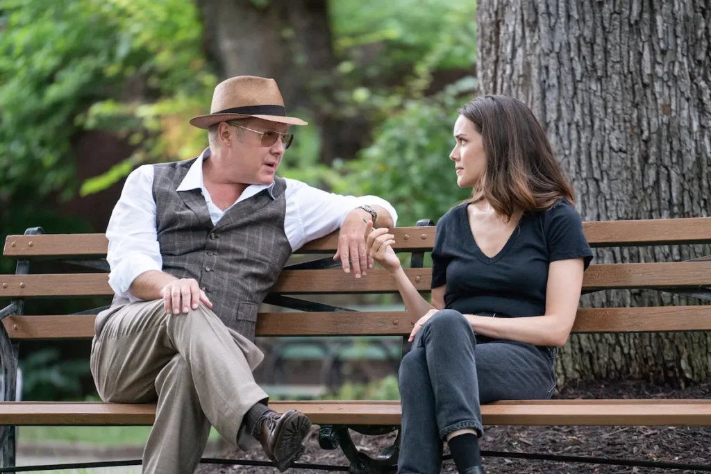 Raymond Reddington ed Elizabeth Keen in una scena di The Blacklist seduti su una panchina