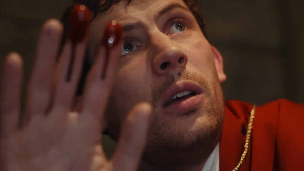 Padre Jud scopre il cadavere di monsignor Wicks in Knives Out